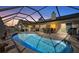 Evening view of a kidney-shaped pool with covered patio at 10 Ocean Pines Dr, Ormond Beach, FL 32174