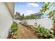 Landscaped walkway with stone path, greenery, and a white fence at 137 Avalon Dr, Ormond Beach, FL 32176