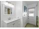 Clean bathroom with white vanity, large mirror, and exterior access at 1408 Ruthbern Rd, Daytona Beach, FL 32114