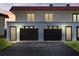 Two-car garage with dark brown doors and a paved driveway at dusk at 41 Ocean Palm Villa S # 41, Flagler Beach, FL 32136