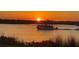 Beautiful sunset over calm water with a pontoon boat at 41 Ocean Palm Villa S # 41, Flagler Beach, FL 32136