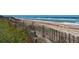 Beach access with wooden staircase and fence at 3072 Ocean Shore Blvd, Ormond Beach, FL 32176