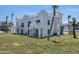 Exterior of a three-story beach house with a Spanish style, manicured lawn, and ocean views at 3072 Ocean Shore Blvd, Ormond Beach, FL 32176