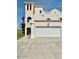 White double-car garage with a three-story Spanish style home at 3072 Ocean Shore Blvd, Ormond Beach, FL 32176