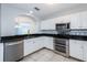 Modern kitchen with white cabinets, black countertops, and stainless steel appliances at 3072 Ocean Shore Blvd, Ormond Beach, FL 32176