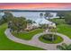 Lakefront property with circular driveway and lush landscaping at 38338 Timberlane Dr, Umatilla, FL 32784