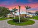 Luxury home with circular driveway and palm trees at sunset at 38338 Timberlane Dr, Umatilla, FL 32784