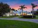 Luxury home with circular drive and palm trees at sunset at 38338 Timberlane Dr, Umatilla, FL 32784