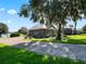 Waterfront home with attached garage and lush landscaping at 38338 Timberlane Dr, Umatilla, FL 32784