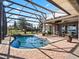 Relaxing kidney-shaped pool with screened enclosure and backyard view at 38338 Timberlane Dr, Umatilla, FL 32784