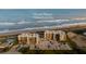 Aerial view of Ocean House condos in Ormond Beach, showing building, pool, and parking at 2222 Ocean Shore Blvd # 102B, Ormond Beach, FL 32176