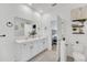 Modern bathroom with double vanity, white cabinets and a large mirror at 4247 Little Owl Ln, Kissimmee, FL 34746