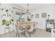 Bright dining room with farmhouse table and chairs, large window, and stylish light fixture at 4247 Little Owl Ln, Kissimmee, FL 34746