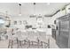 Modern kitchen with white cabinets, stainless steel appliances and an island with seating at 4247 Little Owl Ln, Kissimmee, FL 34746