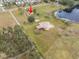 Aerial view of property showing home,red barn, and pond at 1045 Carter Rd, Deland, FL 32724