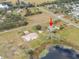 Aerial view of home near a pond with outbuildings at 1045 Carter Rd, Deland, FL 32724