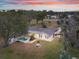 Aerial view of home at sunset with pool and landscaping at 1045 Carter Rd, Deland, FL 32724