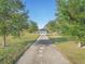 Long driveway to a home surrounded by lush green grass and trees at 1045 Carter Rd, Deland, FL 32724