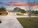 White single story home with attached garage at dusk at 1045 Carter Rd, Deland, FL 32724