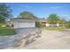 White single story home with attached garage and palm trees at 1045 Carter Rd, Deland, FL 32724