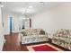 Living room with two floral sofas and a red rug at 1311 Hansberry Ln, Ormond Beach, FL 32174