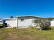 Front exterior view of a single-wide mobile home with small yard and citrus tree at 215 Rue De Paresse, Tavares, FL 32778