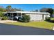 Mobile home with carport, screen enclosure, and well-maintained lawn at 215 Rue De Paresse, Tavares, FL 32778