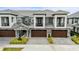 Three townhouses with dark brown garage doors and lush landscaping at 2840 Isles Way, New Smyrna Beach, FL 32168