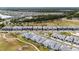 Wide aerial view of community, showcasing townhouses near golf course and lake at 2840 Isles Way, New Smyrna Beach, FL 32168