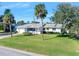 White single story home with palm trees and manicured lawn at 35 Country Club Dr, Ormond Beach, FL 32176