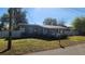 Gray house with a green lawn and white fence at 623 Unabelle Ave, Holly Hill, FL 32117