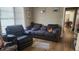 Cozy living room featuring a brown leather recliner and sofa, hardwood floors, and a view into the dining area at 623 Unabelle Ave, Holly Hill, FL 32117