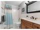 A bathroom with a wood vanity, marble countertop, framed mirror and shower-tub with a blue shower curtain at 66 Ocean Palm Villa S, Flagler Beach, FL 32136