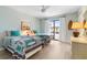 Light-filled bedroom featuring two twin beds with coastal-themed decor and sliding glass doors with white curtains at 66 Ocean Palm Villa S, Flagler Beach, FL 32136