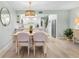 Bright dining area open to a kitchen featuring white cabinets and stainless appliances, with modern light fixture at 66 Ocean Palm Villa S, Flagler Beach, FL 32136