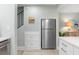 Kitchen area featuring stainless steel refrigerator, white cabinets and drawers, and light wood-look flooring at 66 Ocean Palm Villa S, Flagler Beach, FL 32136