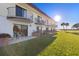 Condo patio with seating and balconies overlooking a well-maintained lawn and waterfront at 66 Ocean Palm Villa S, Flagler Beach, FL 32136