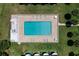 Aerial view of a rectangular community pool with lounge chairs and tables surrounded by a brick patio and green grass at 66 Ocean Palm Villa S, Flagler Beach, FL 32136