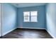 Light blue bedroom with dark wood floors and a window at 707 Hang Loose Way, Daytona Beach, FL 32124