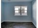 Light blue bedroom with dark wood flooring and a window at 707 Hang Loose Way, Daytona Beach, FL 32124