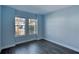 Blue bedroom with dark wood floors and two windows at 707 Hang Loose Way, Daytona Beach, FL 32124