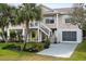 Two-story elevated beach home with palm trees and a spacious yard at 124 Avalon Dr, Ormond Beach, FL 32176