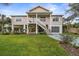 Two-story elevated beach home with palm trees and a spacious yard at 124 Avalon Dr, Ormond Beach, FL 32176