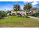 Two-story elevated beach home with palm trees and a spacious yard at 124 Avalon Dr, Ormond Beach, FL 32176