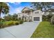 Two-story elevated beach home with palm trees and a spacious yard at 124 Avalon Dr, Ormond Beach, FL 32176