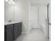 Bathroom with dark gray vanity, quartz countertop, and tiled shower at 2840 Monaghan Dr, Ormond Beach, FL 32174