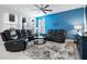 Spacious living room with reclining sofas, a large TV, and a blue accent wall at 2840 Monaghan Dr, Ormond Beach, FL 32174