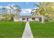 Ranch-style home with mature landscaping and palm tree at 89 Hickory Hills Cir, Ormond Beach, FL 32174