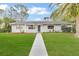 Gray house with a front yard, walkway, and palm tree at 89 Hickory Hills Cir, Ormond Beach, FL 32174