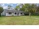 Gray house with a well-manicured lawn and palm trees at 89 Hickory Hills Cir, Ormond Beach, FL 32174